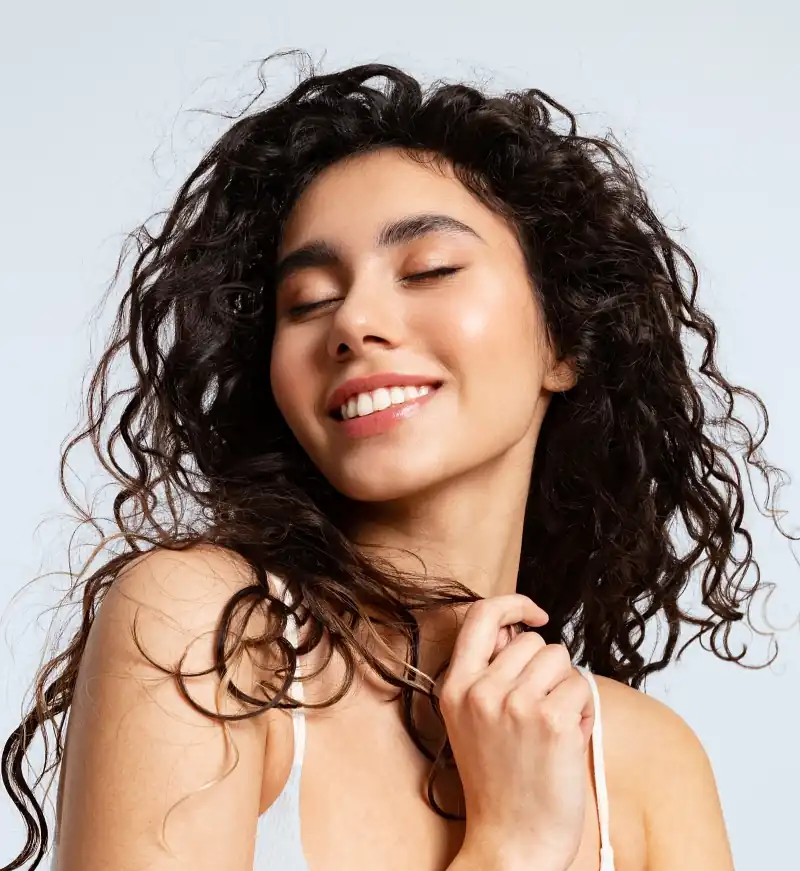 Happy young woman with natural beauty, and beautiful curly hair smiling