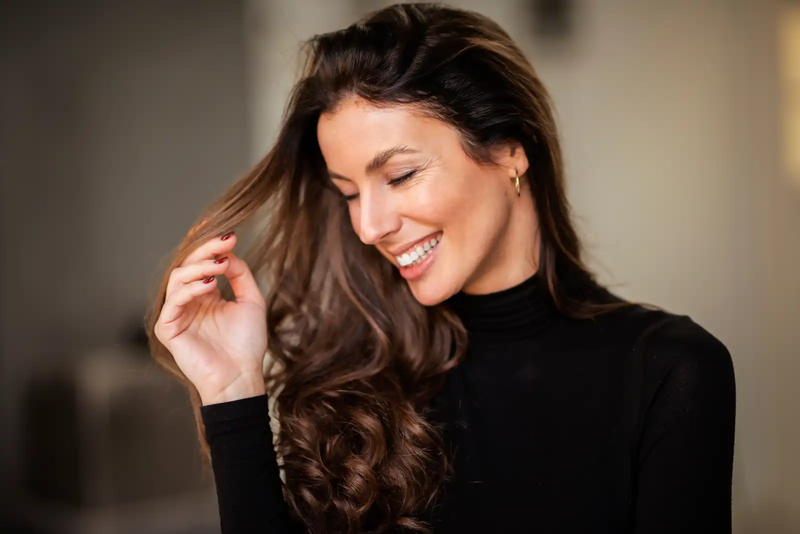woman smiling and holding her hair